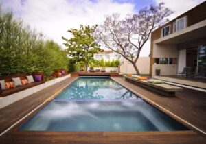 amenagement-jardin-terrasse-bois-piscine-bain à remous-bancs-coussins-arbres